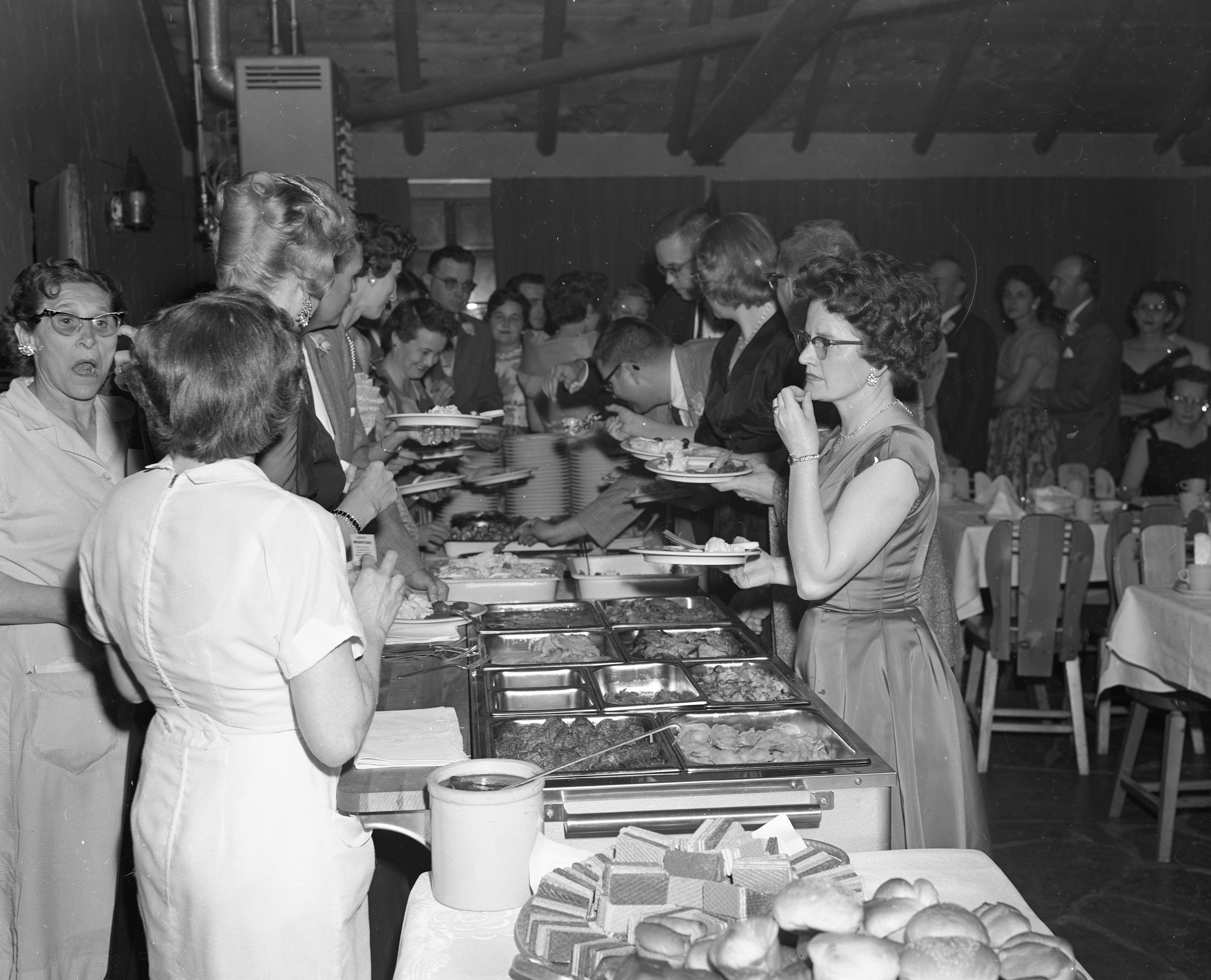 Convair employees and other guests getting food from the buffet line at the dance event.